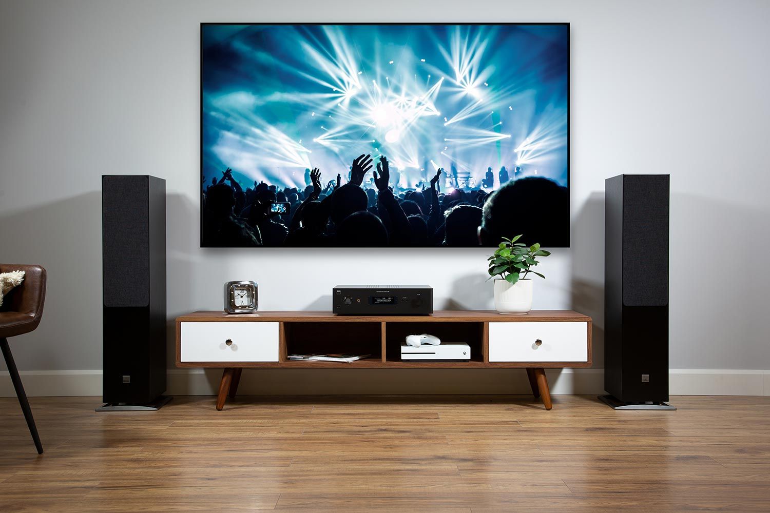 Contemporary media room with a large screen displaying a concert, flanked by floor-standing speakers and a sleek entertainment console.