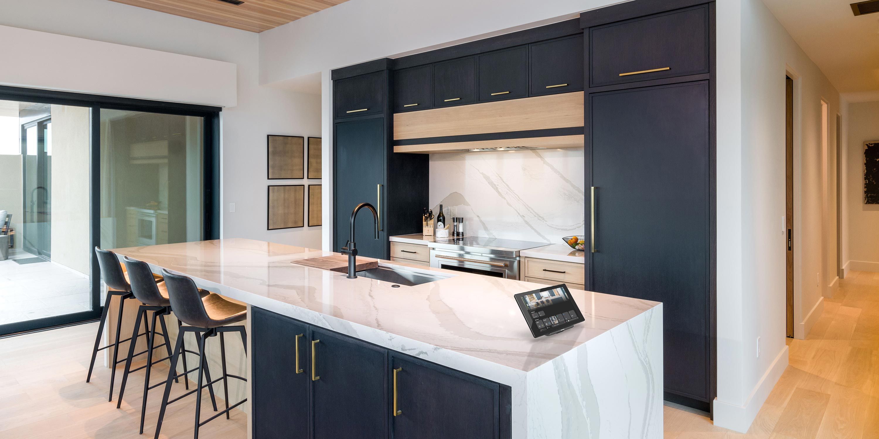 A sleek, contemporary kitchen featuring a large marble island, dark cabinetry, and bar seating, designed for both cooking and socializing.